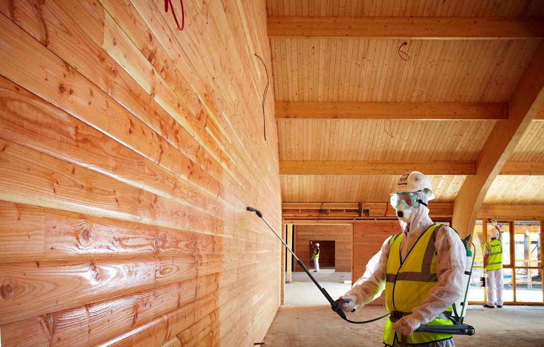 impregnacja drewna wewnątrz budynku, pracownicy impregnują drewniane ściany